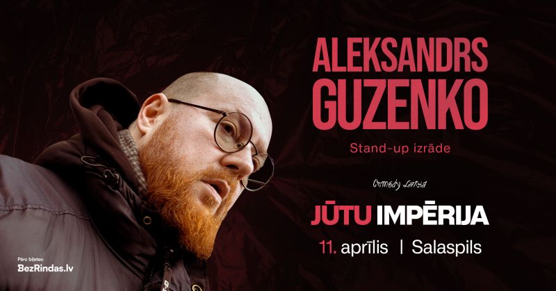 Plakāts ar Aleksandru Guzenko, vīrieti ar sarkanu bārdu un brillēm, reklamē stand-up izrādi. Teksts: ALEKSANDRS GUZENKO. Stand-up izrāde. Comedy Latvia. JŪTU IMPĒRIJA. 11. aprīlis | Salaspils. Pērc biļetes: BezRindas.lv.